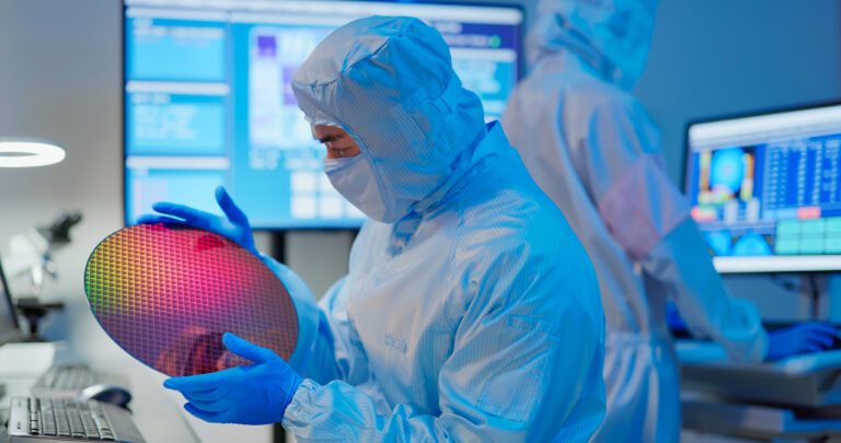 semiconductor technician with wafer in manufacturing plant