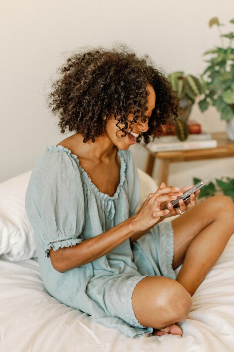 woman using phone in bed 865x1298