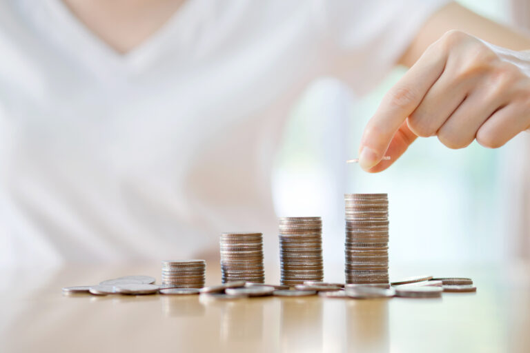 a person putting coins on steadily rising stacks