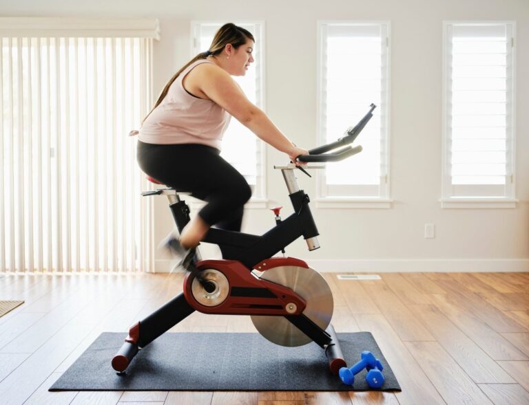 person on exercise bike at home kRawtlc