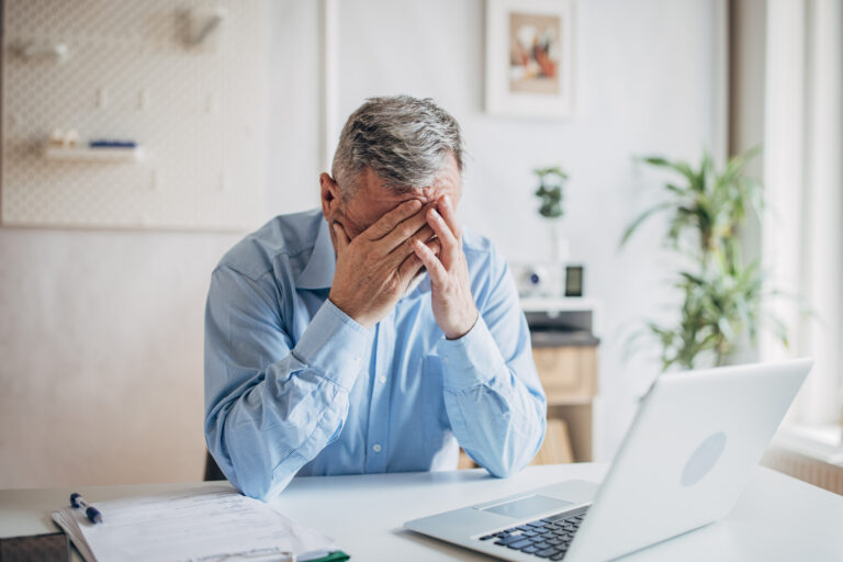 senior man laptop covering face gettyimages 1472263927