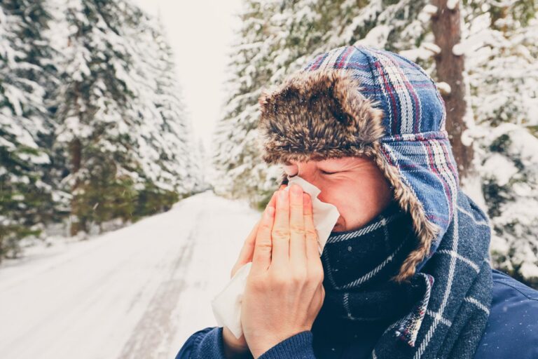 Ill man with paper tissue in winter nature