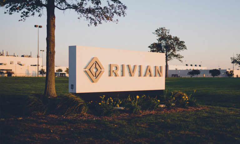 building with rivian logo sign on front lawn rivian