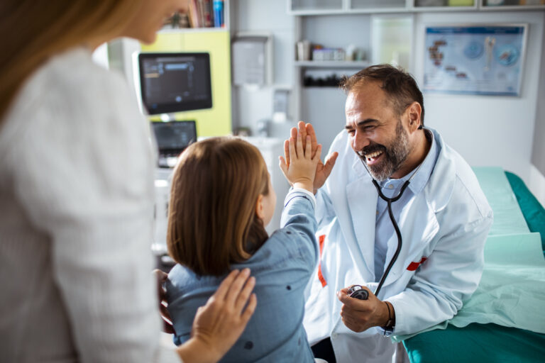 physician giving a high five to a young patient