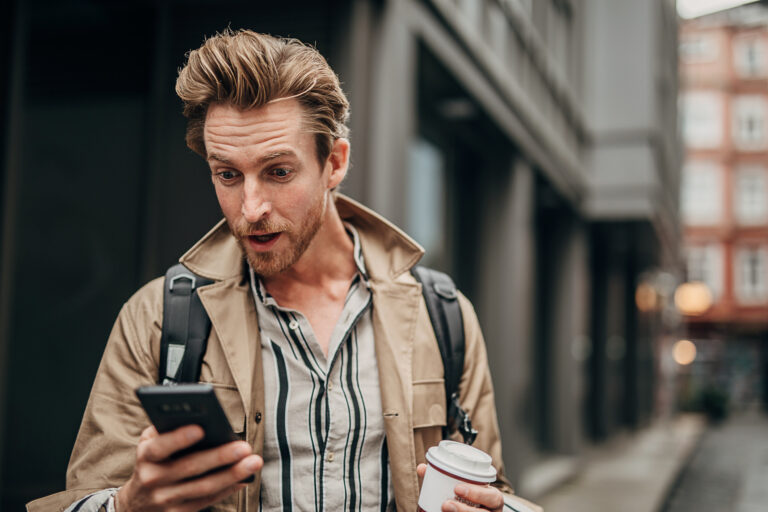 surprised person using phone on the street in city