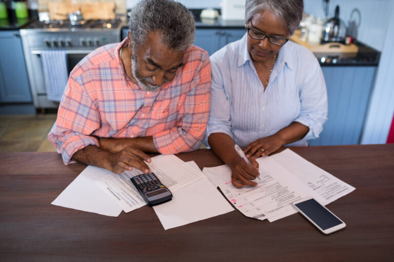 two people looking at documents and a calculator