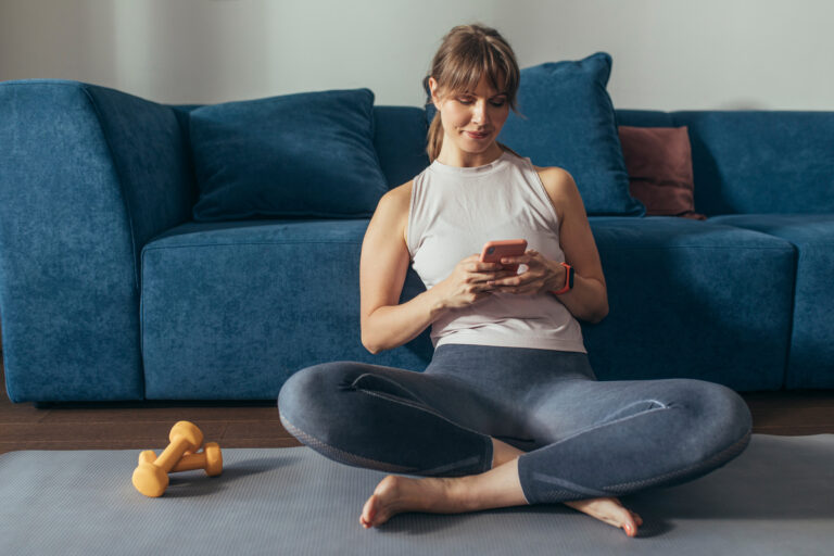 wearing workout clothes dumbbells sitting down phone