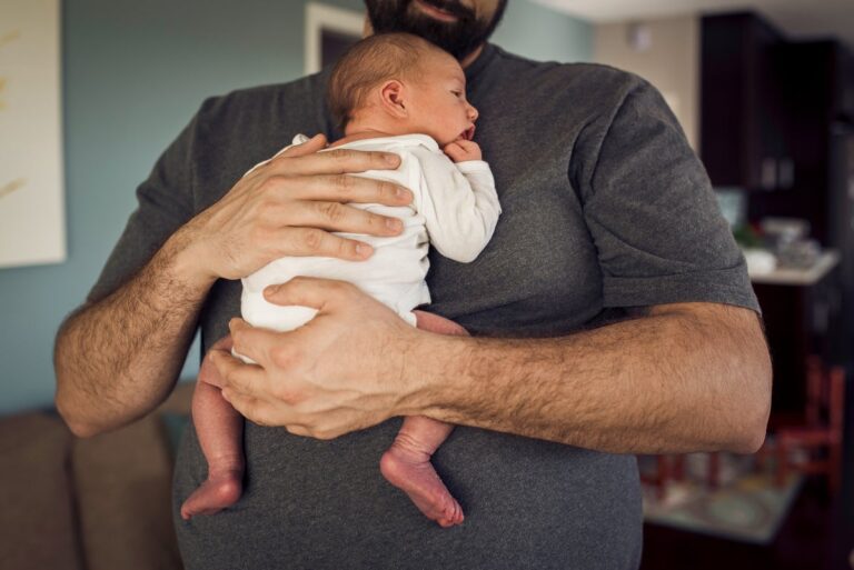 father holding baby at home