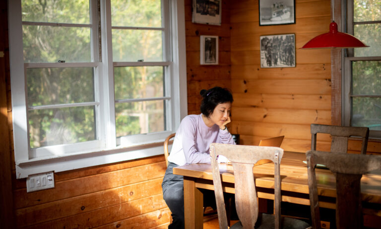 person on computer in cabin airbnb