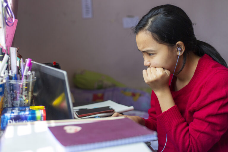person looking unhappily at a laptop pc